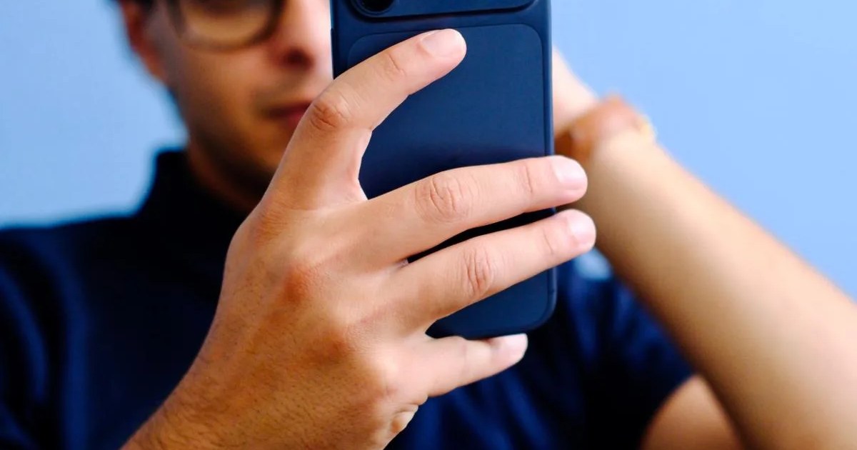 Mann nutzt sein Smartphone, um online einen Termin zu buchen